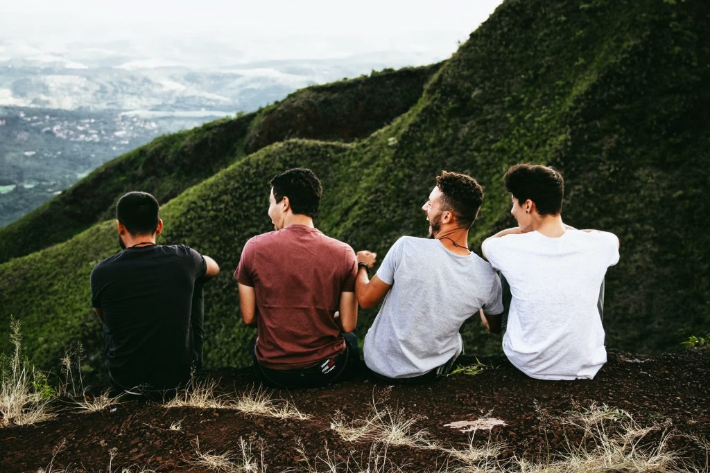 Group of four young men sitting on a mountain