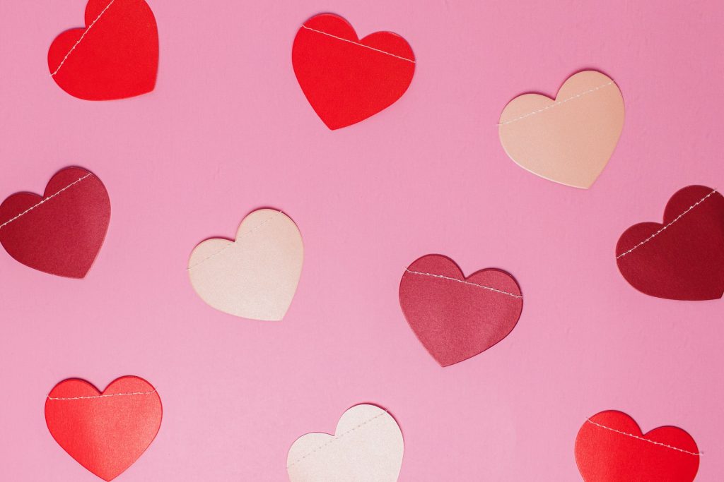 Cut out felt hearts hanging on a pink wall