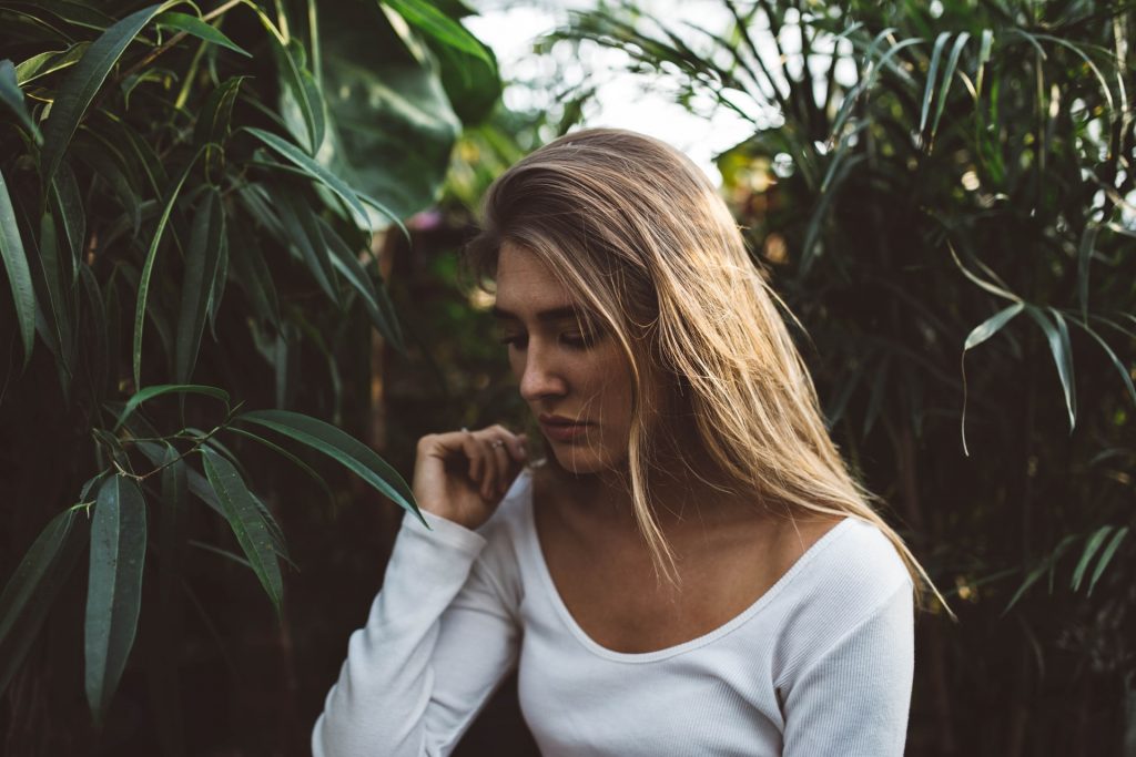 Women who is sad outside by some plants