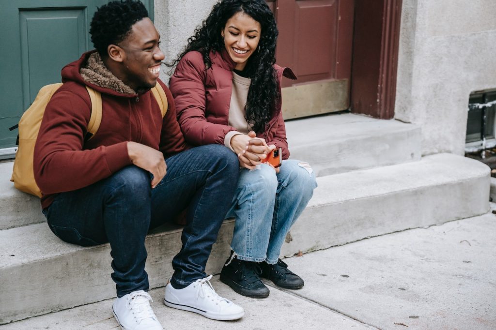 couple sitting on stairs holding hands smiling