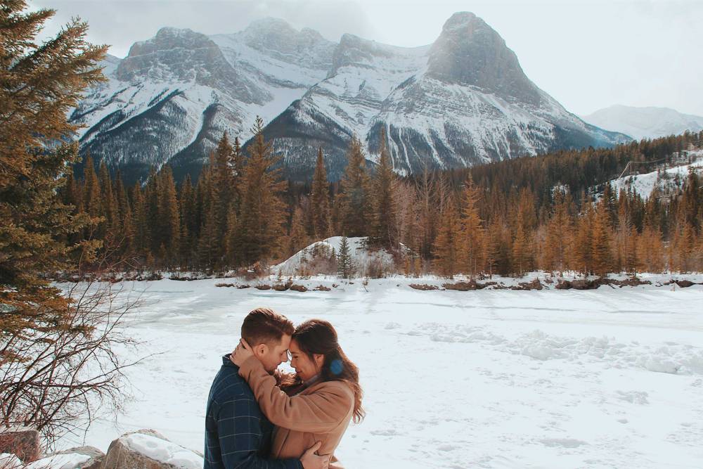 Man and woman in Canada embracing each other near mountains