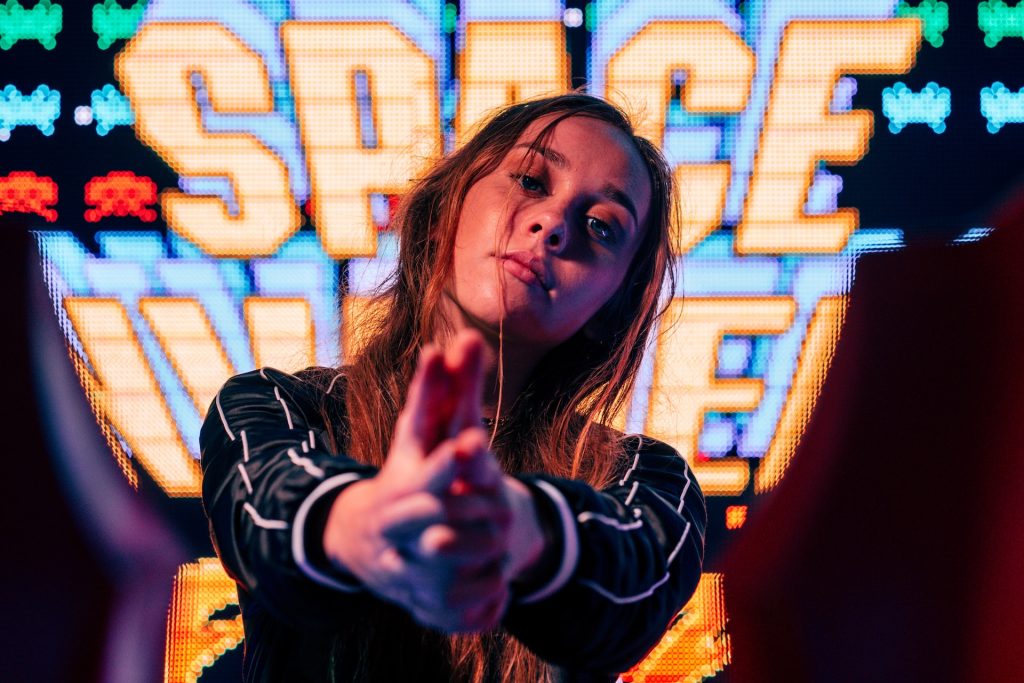Girl at an arcade in front of Space Invaders