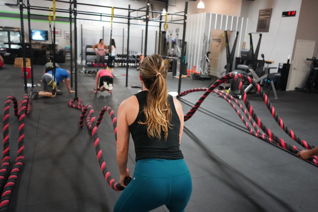 Girls at the gym working out on battle ropes