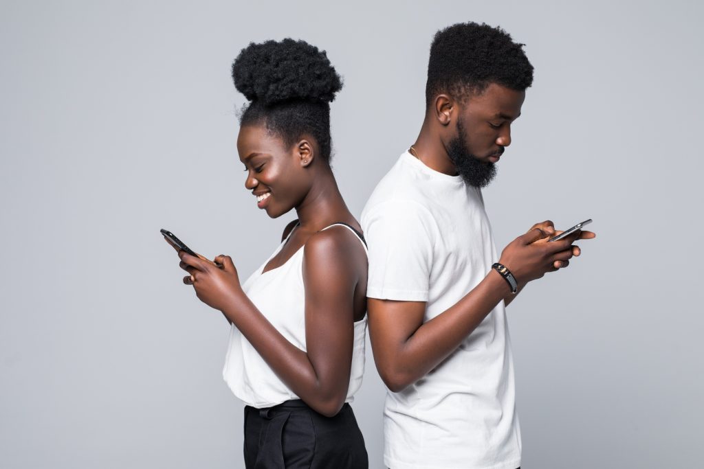 Black couple using their phones looking at dating apps