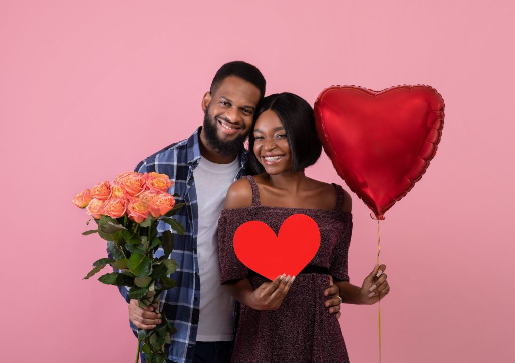 Young Black Couple Holding Valentines Day Gifts and Smiling